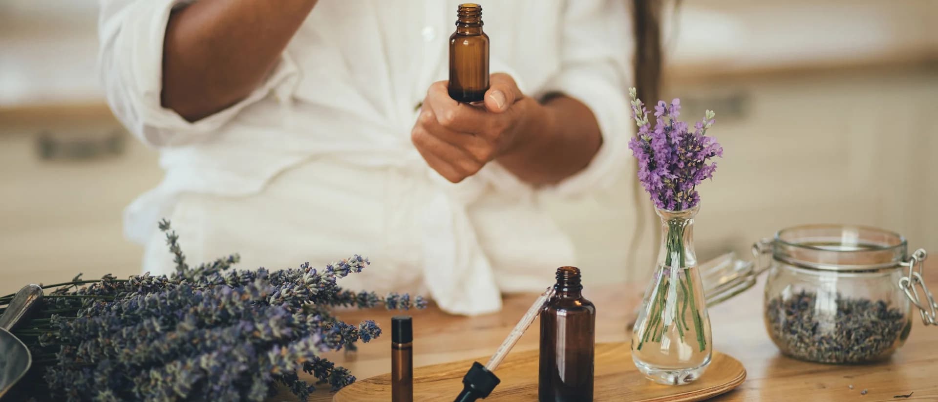 Heller Tisch mit Lavendel und dunklen Tropffläschchen