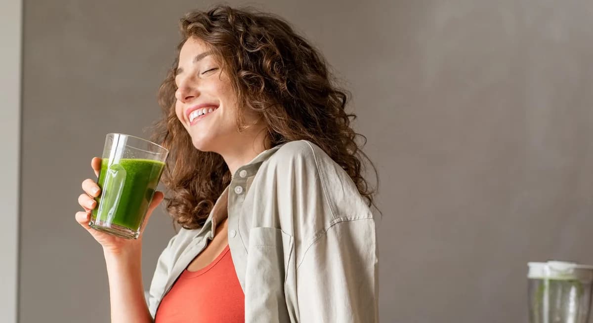 Frau genießt einen grünen Smoothie
